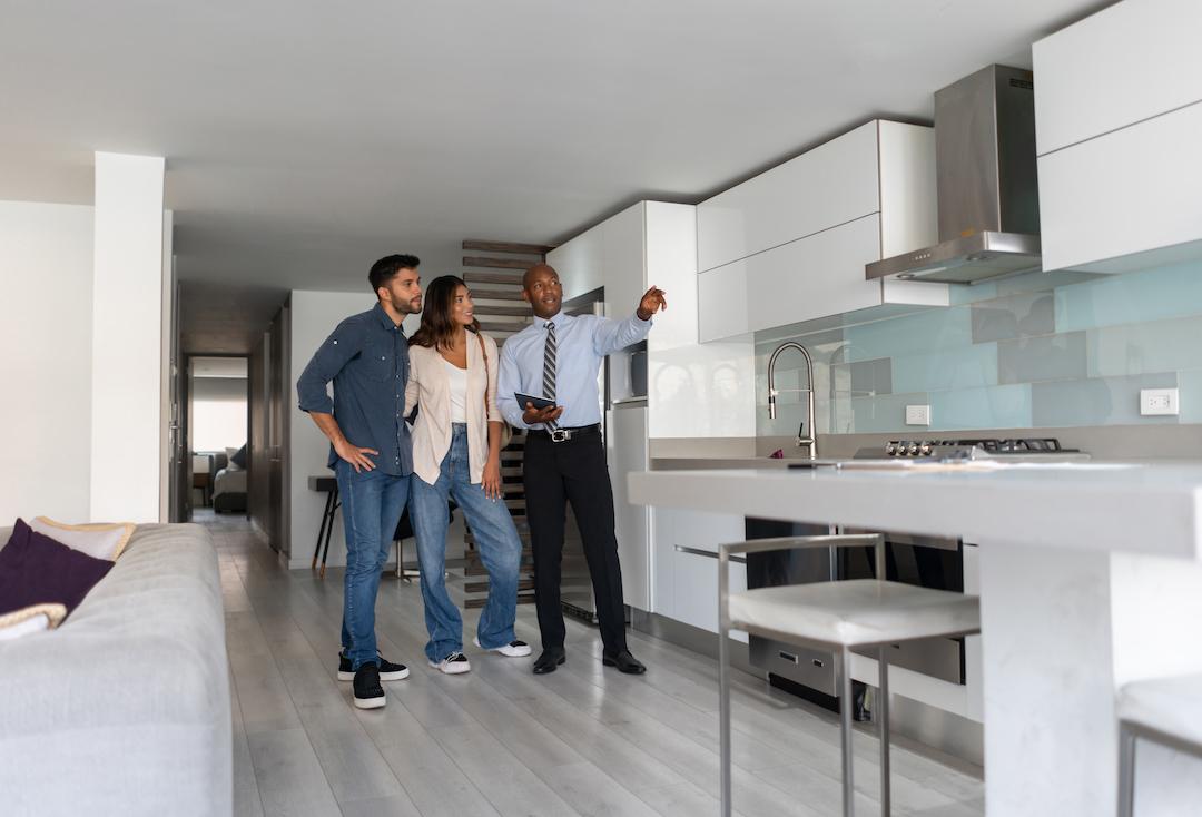 Un agente inmobiliario mostrando una vivienda a una pareja que ha firmado el contrato de arras